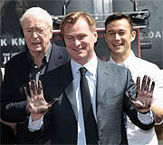 Nolan muestra sus manos tras inmortalizarlas en cemento, ante Michael Caine y Joseph Gordon-Levitt (Reuters)